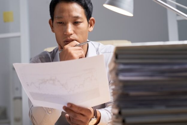 書類を前に考え込む採用担当者
